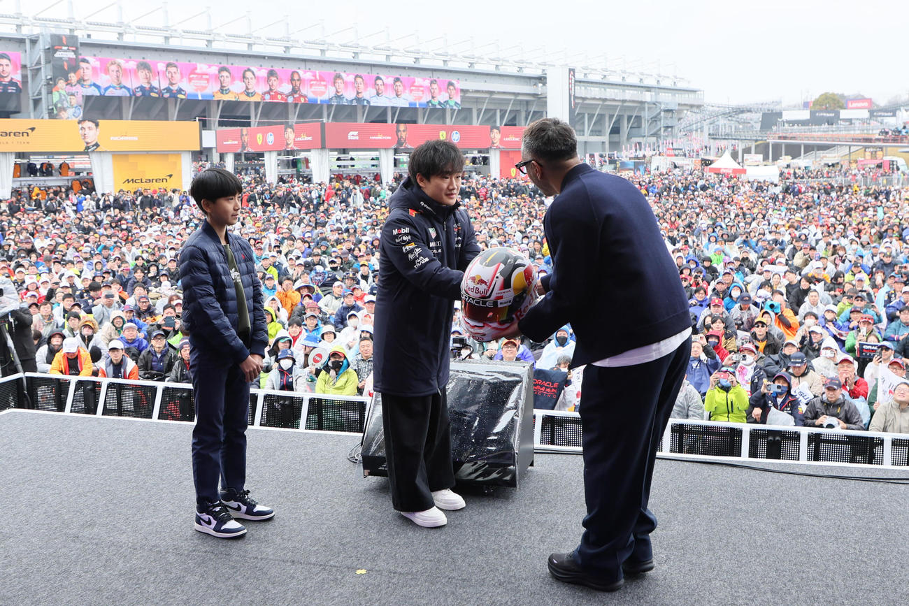 GPスクエアでトークショーを行った市川團十郎（右）、新之助さん（左）は、角田裕毅からサイン入りヘルメットをプレゼントされる（撮影・宮崎幸一）