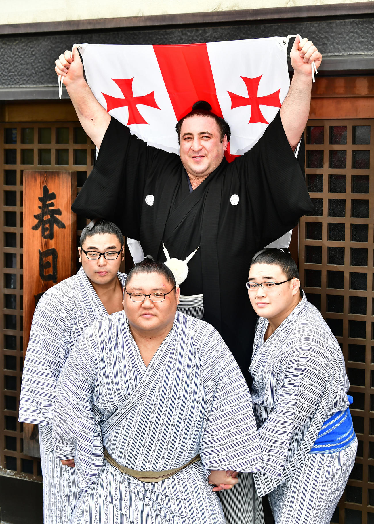 大関昇進伝達式を終えた栃ノ心（中央）はジョージア国旗を掲げて、部屋の若い衆が作った騎馬上で笑顔を見せる（2018年5月30日撮影）