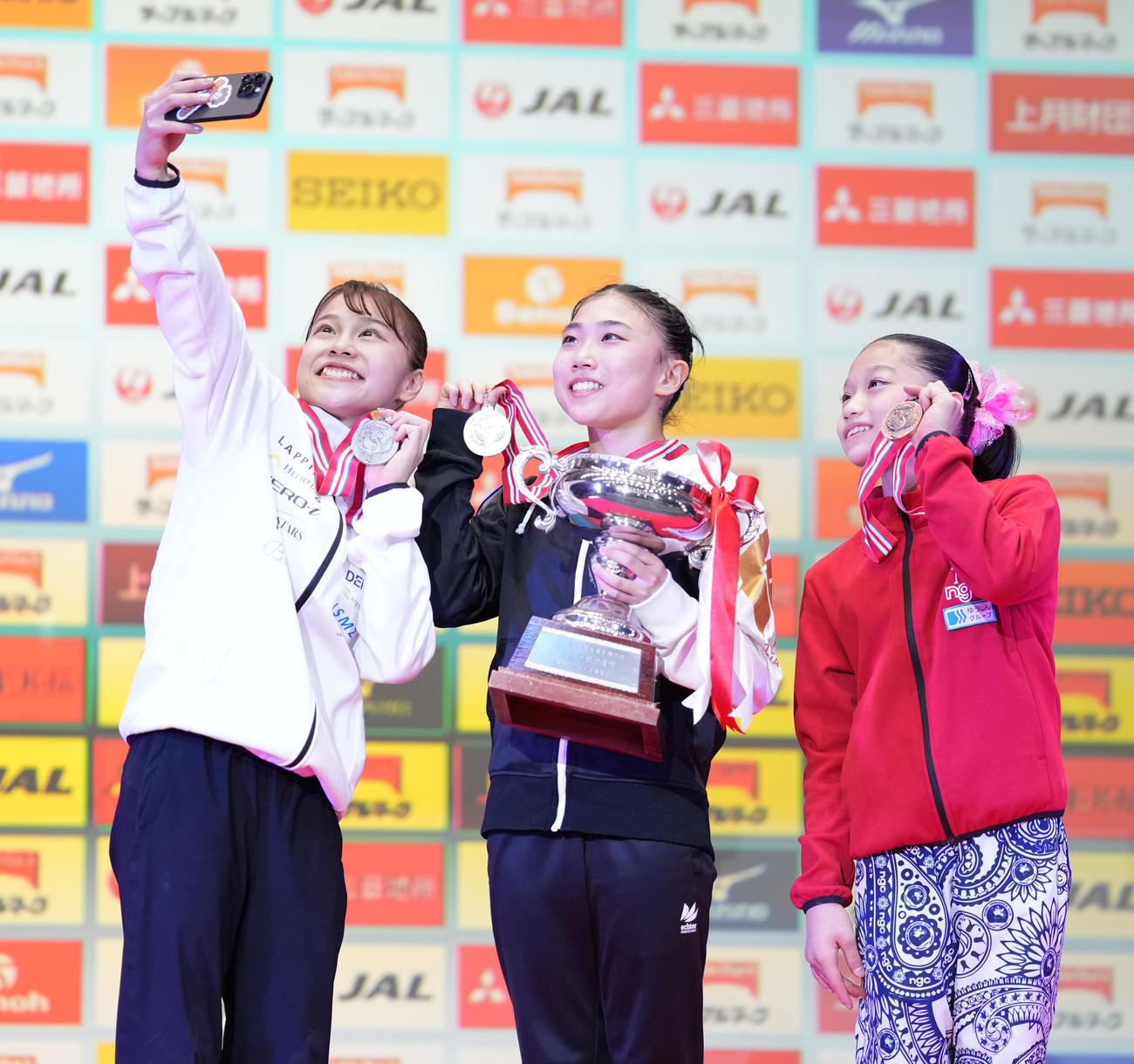 女子決勝　表彰式で自撮りする、左から2位の杉原、優勝の岸、3位の南埜（撮影・鈴木みどり）