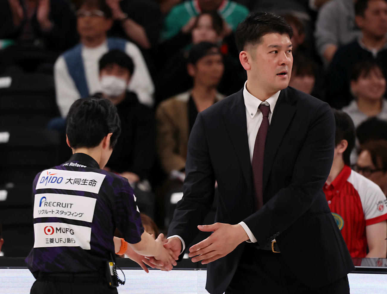 SVリーグ女子チャンピオンシップファイナル　ゲーム1　大阪MV対NEC川崎　試合に敗れた川崎の金子隆行ヘッドコーチは審判団と握手を行う（撮影・山本朝陽）