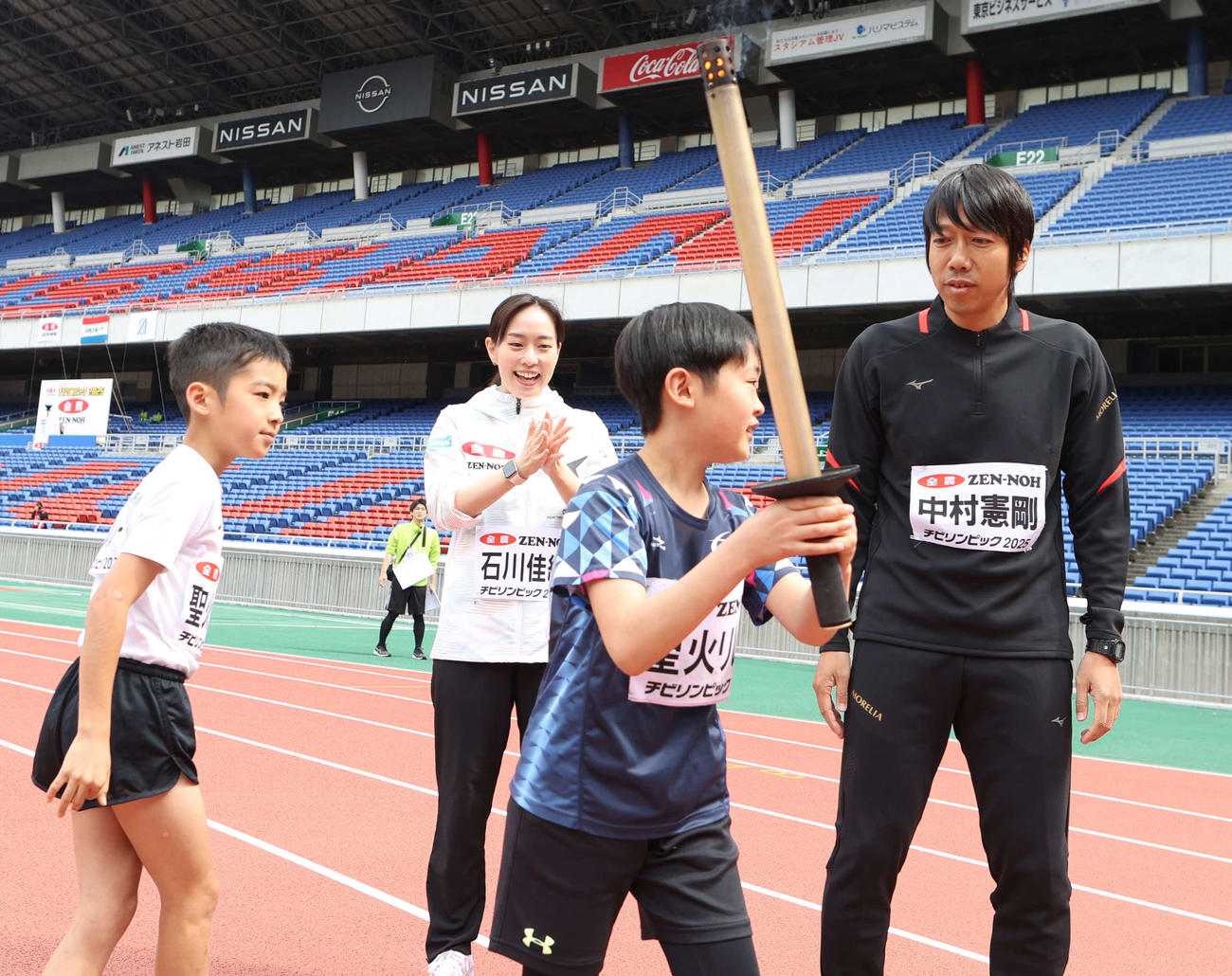 聖火リレーに参加する中村憲剛（右）。左から2人目は石川佳純（撮影・水谷安孝）