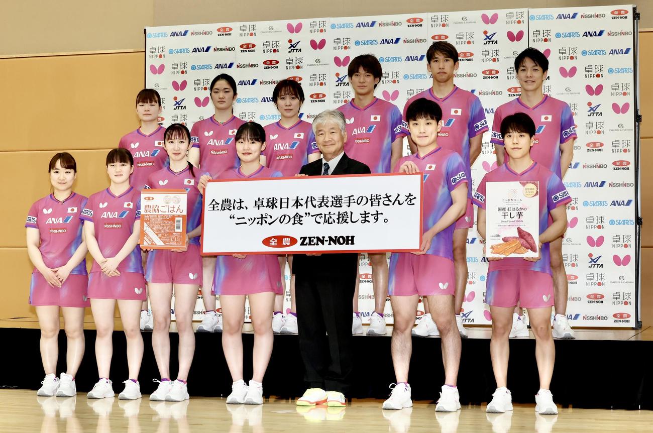 全国農業協同組合連合会の安田代表理事専務（中央）と写真に納まる卓球日本代表選手団。前列左から伊藤、大藤、早田、張本美、1人おいて張本智、篠塚、後列左から横井、木原、平野、戸上、吉村、松平（撮影・河田真司）