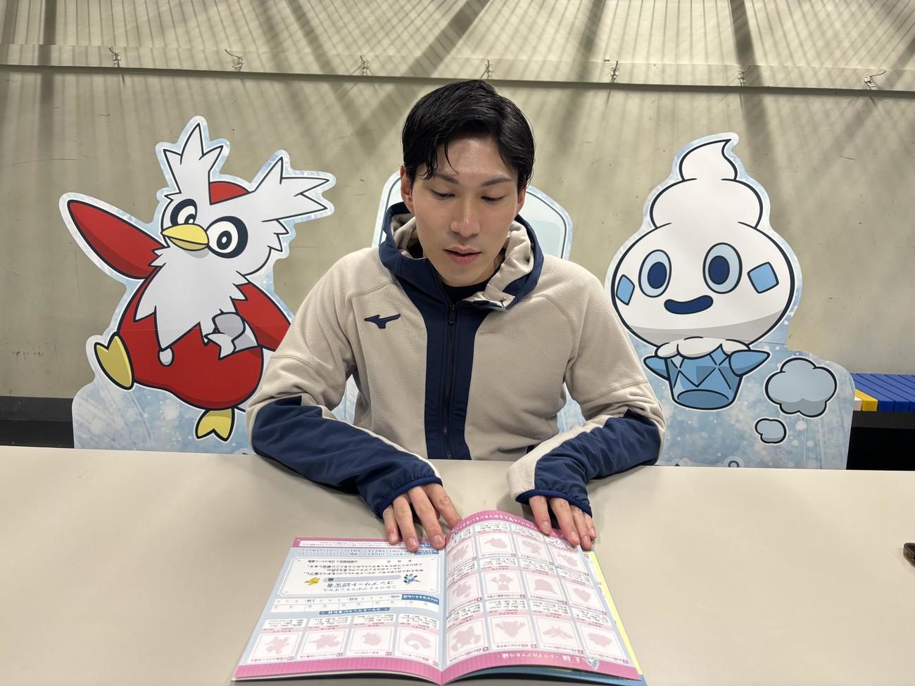 ポケモンスケートチャレンジで用いられる練習用冊子を手に説明する田中刑事さん（撮影・松本航）（C）2025 Pokemon.（C）1995－2025 Nintendo／Creatures Inc.／GAME FREAK inc.