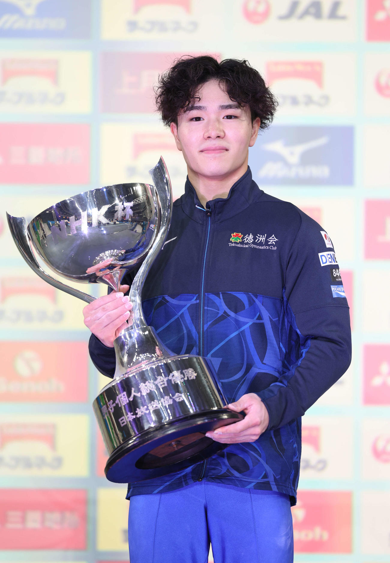 優勝トロフィーを手にもつ岡（撮影・増田悦実）
