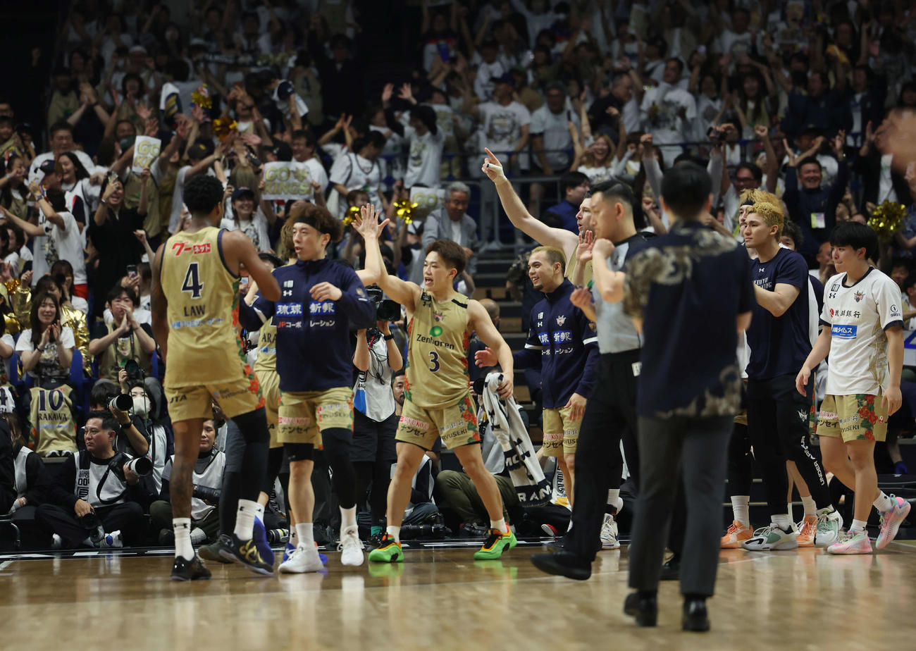 勝利しハイタッチをし合う琉球ゴールデンキングスメンバー（撮影・増田悦実）