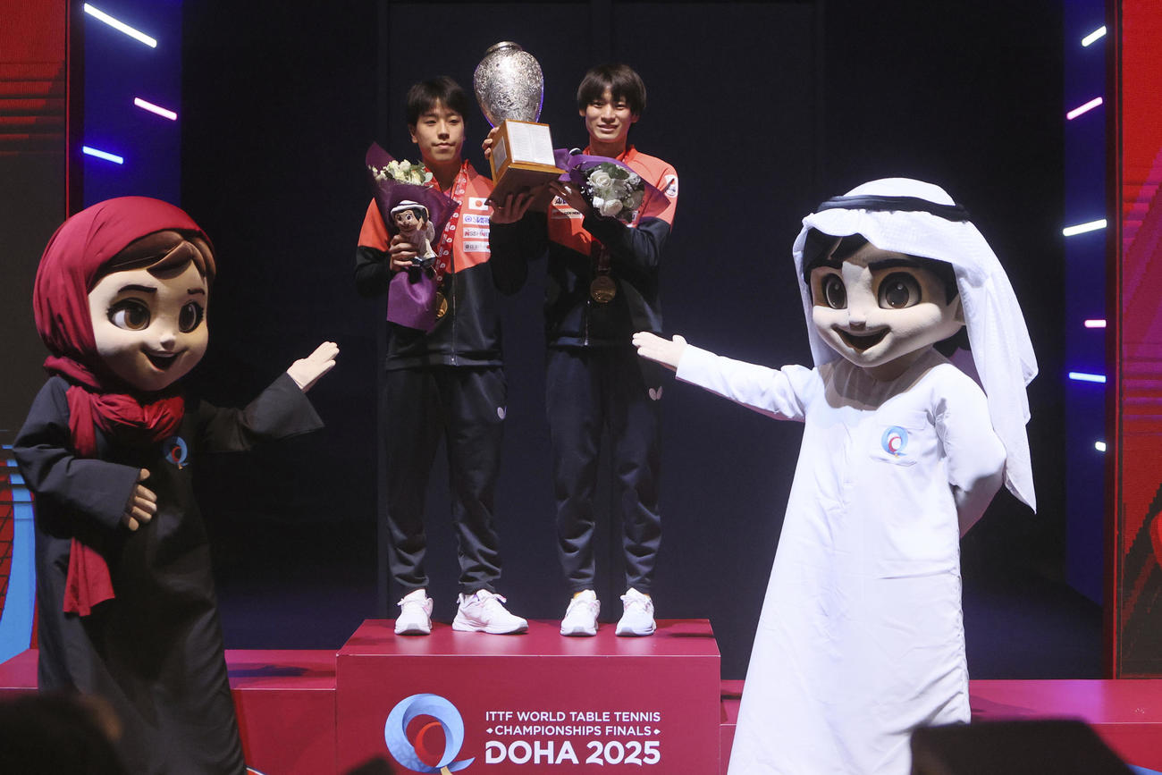 男子ダブルスで優勝し、トロフィーを手に喜ぶ篠塚大登と戸上隼輔(AP)
