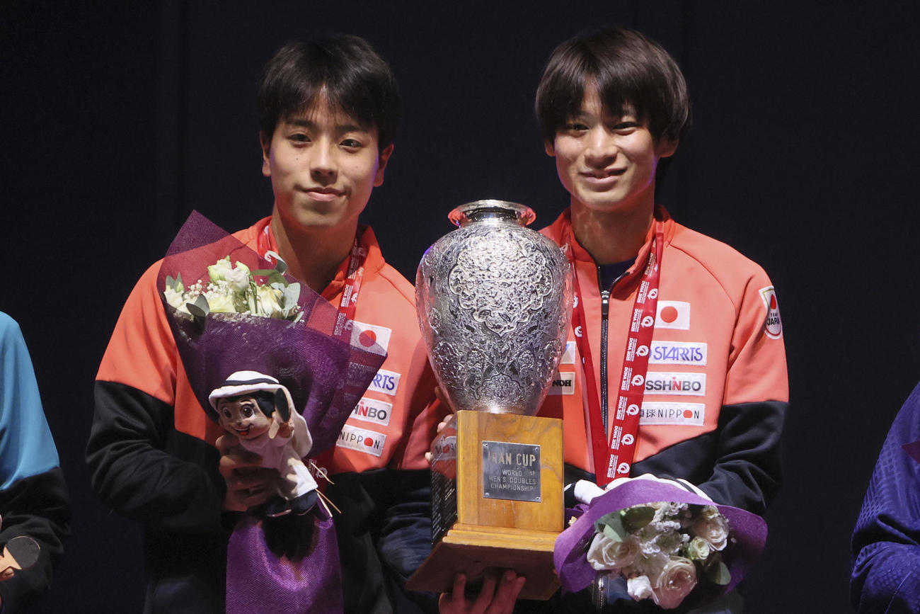 男子ダブルスで優勝し、トロフィーを手に喜ぶ篠塚大登と戸上隼輔(AP)