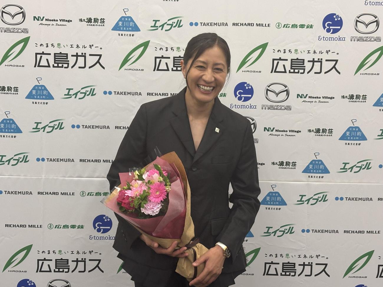 花束を手に写真に納まる竹内智香（撮影・勝部晃多）