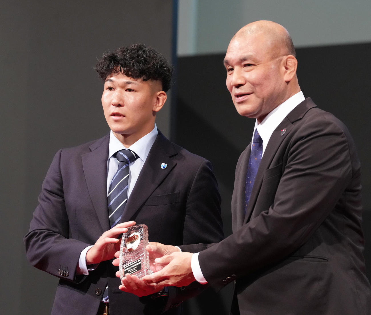 新人賞を受賞した静岡北村（左）はジャパンラグビーリーグワン理事福本氏からトロフィーを受け取る（撮影・足立雅史）