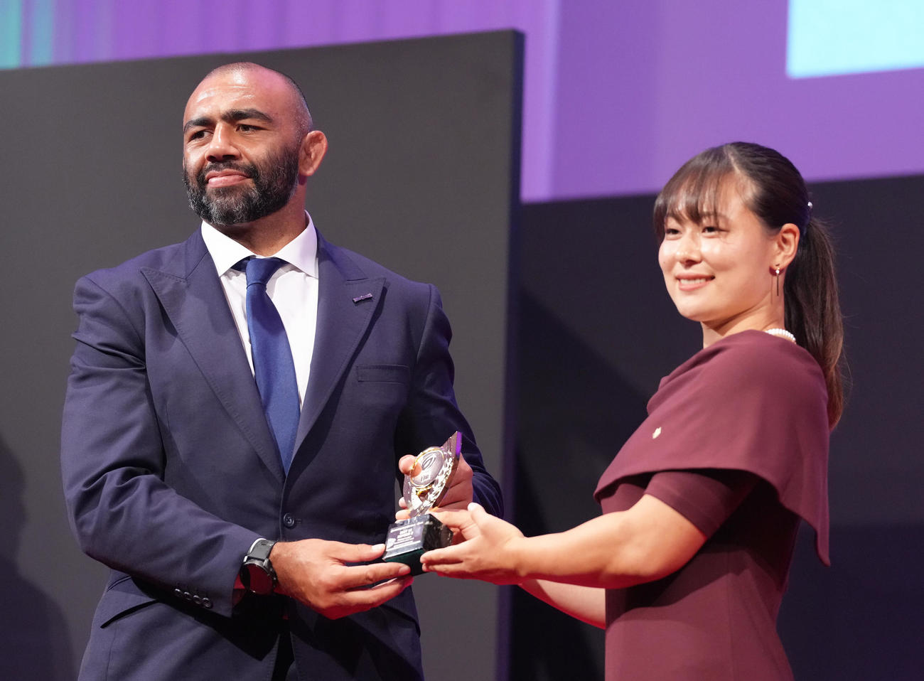 ベストフィフティーンを受賞したBL東京NO8リーチ（左）は女子ラグビー長田からトロフィーを受け取る（撮影・足立雅史）