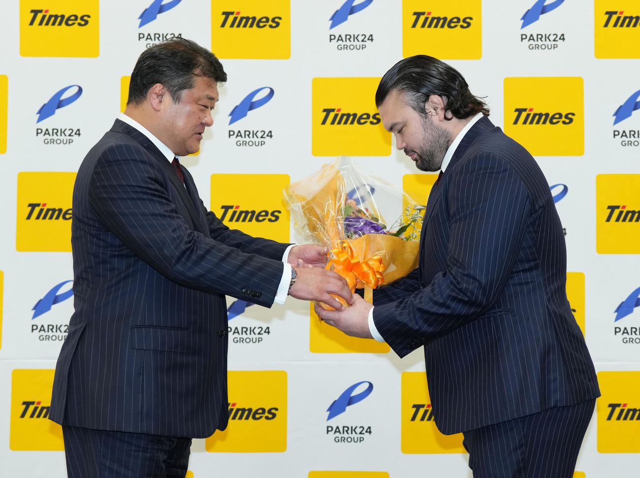 引退会見で吉田総監督（左）から花束を受け取るウルフ・アロン（撮影・菅敏）