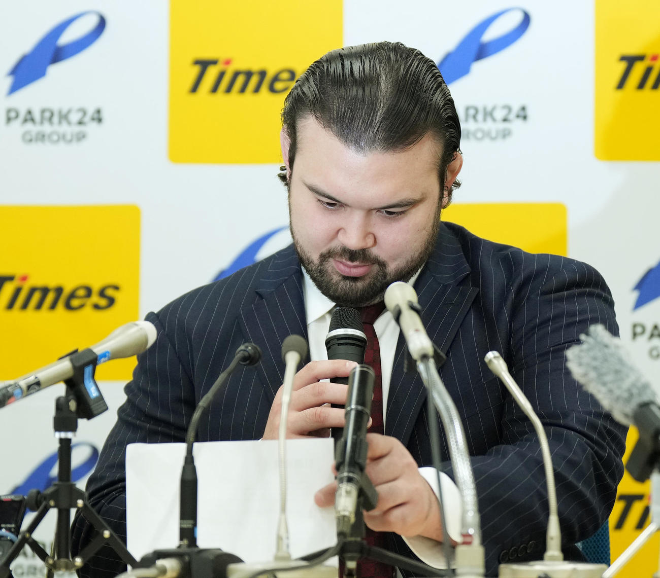 会見で引退を報告するウルフ・アロンは、途中でカンペを見つめる（撮影・菅敏）