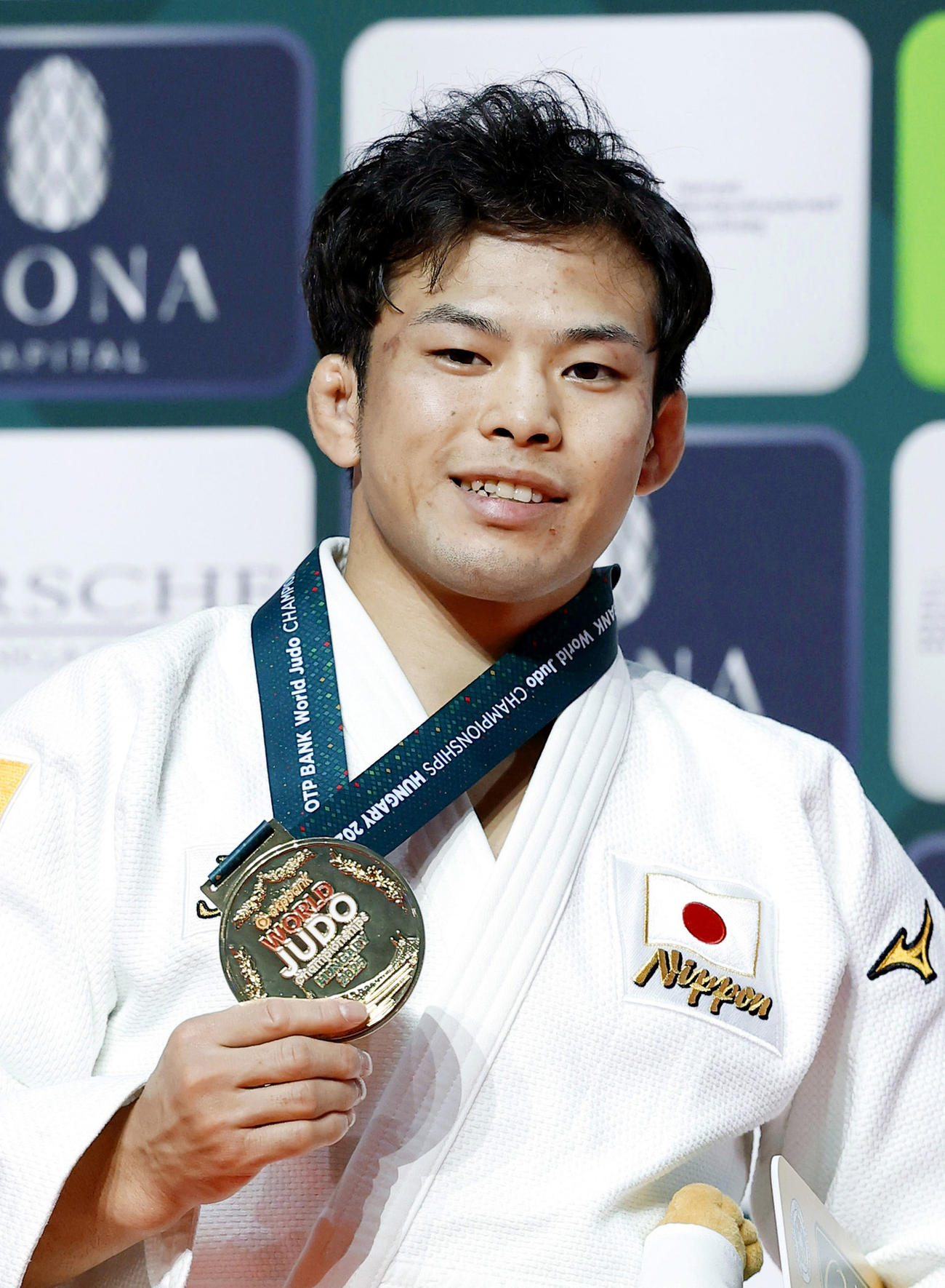 柔道の世界選手権男子60キロ級で初優勝を果たし、金メダルを手に笑顔を見せる永山竜樹（共同）