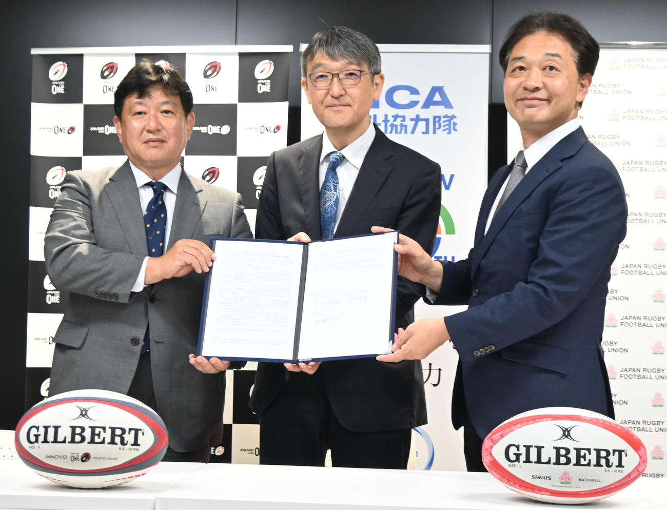 「ラグビーを通じた国際協力と共生社会の実現に向けた3者連携協定」調印式に臨んだ、左からリーグワンの東海林一専務理事、国際協力機構（JICA）の小林広幸理事、日本ラグビー協会の岩渕健輔専務理事（撮影・飯岡大暉）
