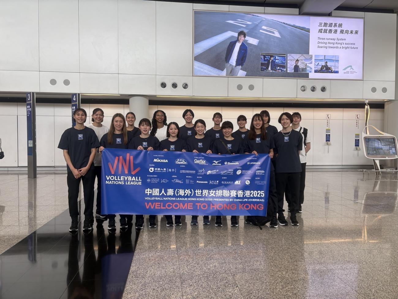 空港で笑顔で写真に納まる女子日本代表（C）JVA
