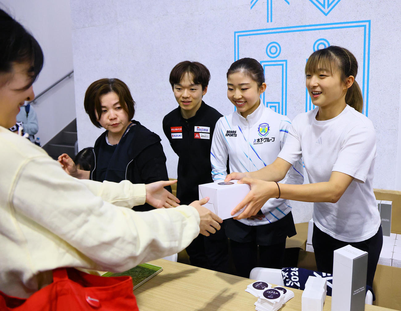 フィギュアの五輪対策合宿公開練習で、グッズ販売の手伝いをする右から坂本花織、千葉百音、鍵山優真（撮影・藤尾明華）