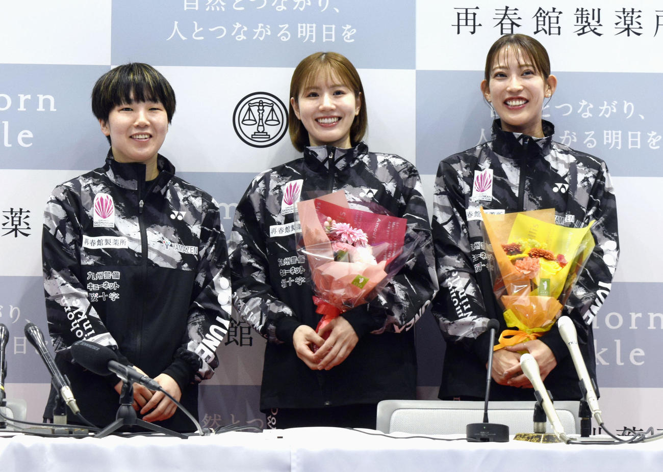 記者会見でペア解消を発表した志田千陽（中央）、松山奈未（右）組に花束を贈った山口茜（左）