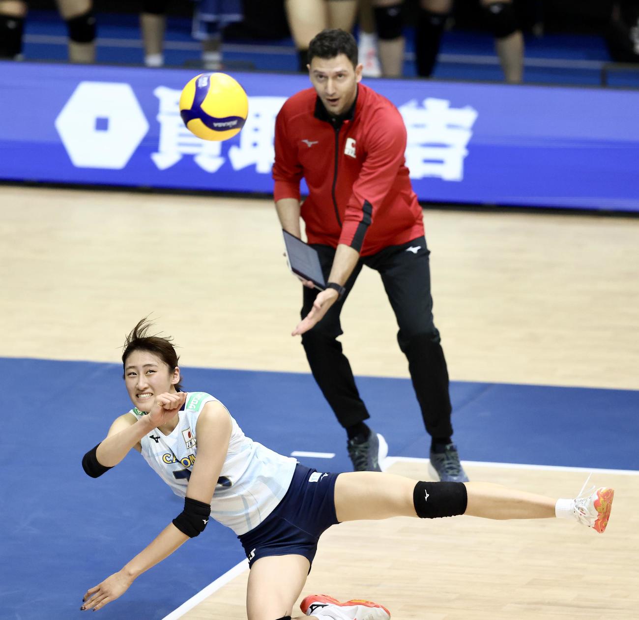 日本対韓国　第2セット、ボールに食らいつく秋本。後方はアクバシュ監督（撮影・河田真司）