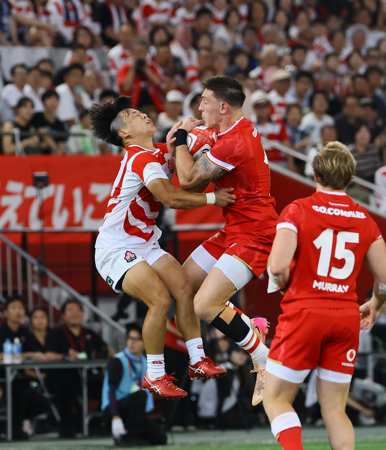 日本対ウェールズ　前半、ハイボールを競り合う日本石田（左）とウェールズのアダムス（撮影・藤尾明華）