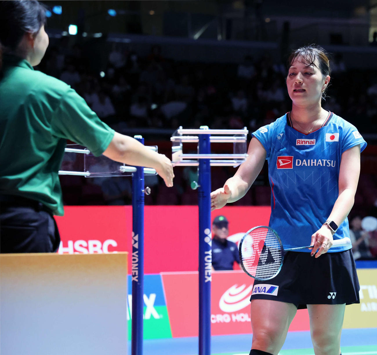 バドミントンジャパンオープン　女子ダブルス1回戦　試合に敗れ浮かない表情で審判と握手を交わす福島（右）（撮影・山本朝陽）