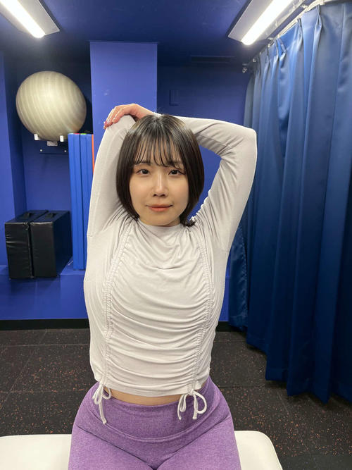 反対の手で、曲げている肘を斜め下に押す