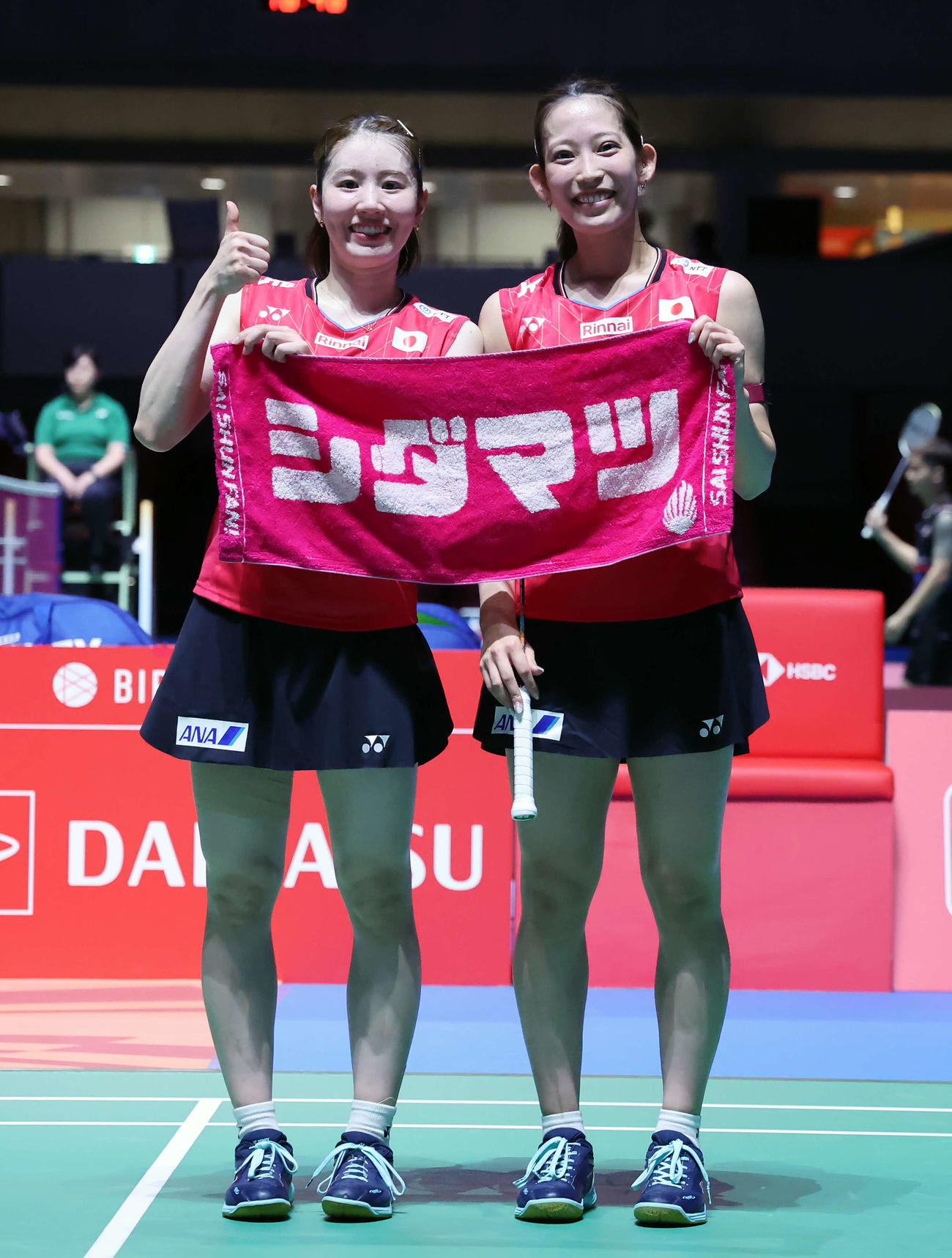 バドミントンジャパンオープン　女子ダブルス1回戦　広上・保原組対志田・松山組　シダマツと描かれたタオルを掲げ、撮影に応じる志田（左）松山組（撮影・山本朝陽）