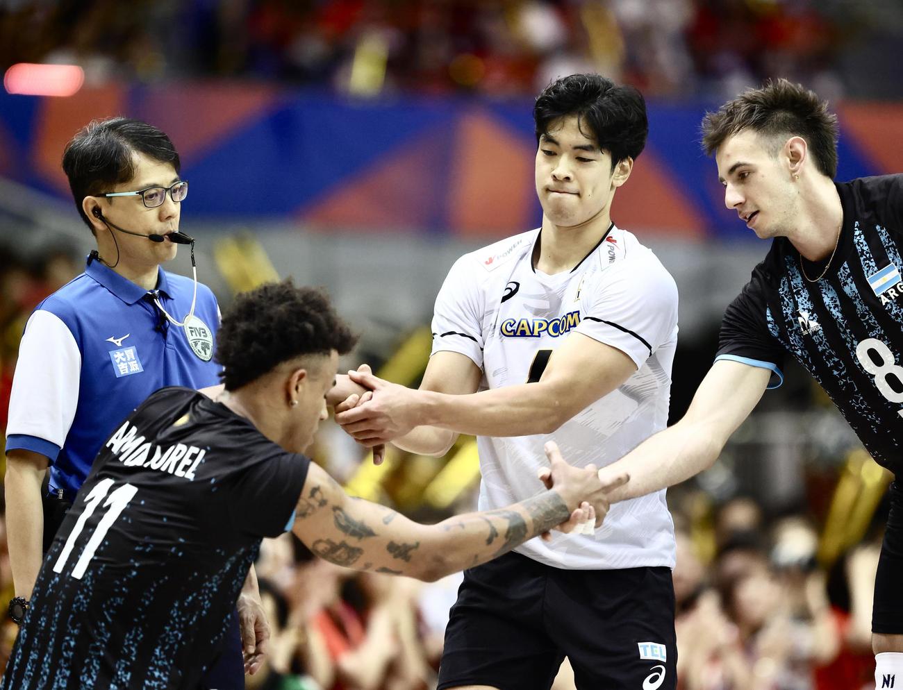 日本対アルゼンチン　第3セット、ポイントした宮浦はアルゼンチンの選手を起こす（撮影・河田真司）