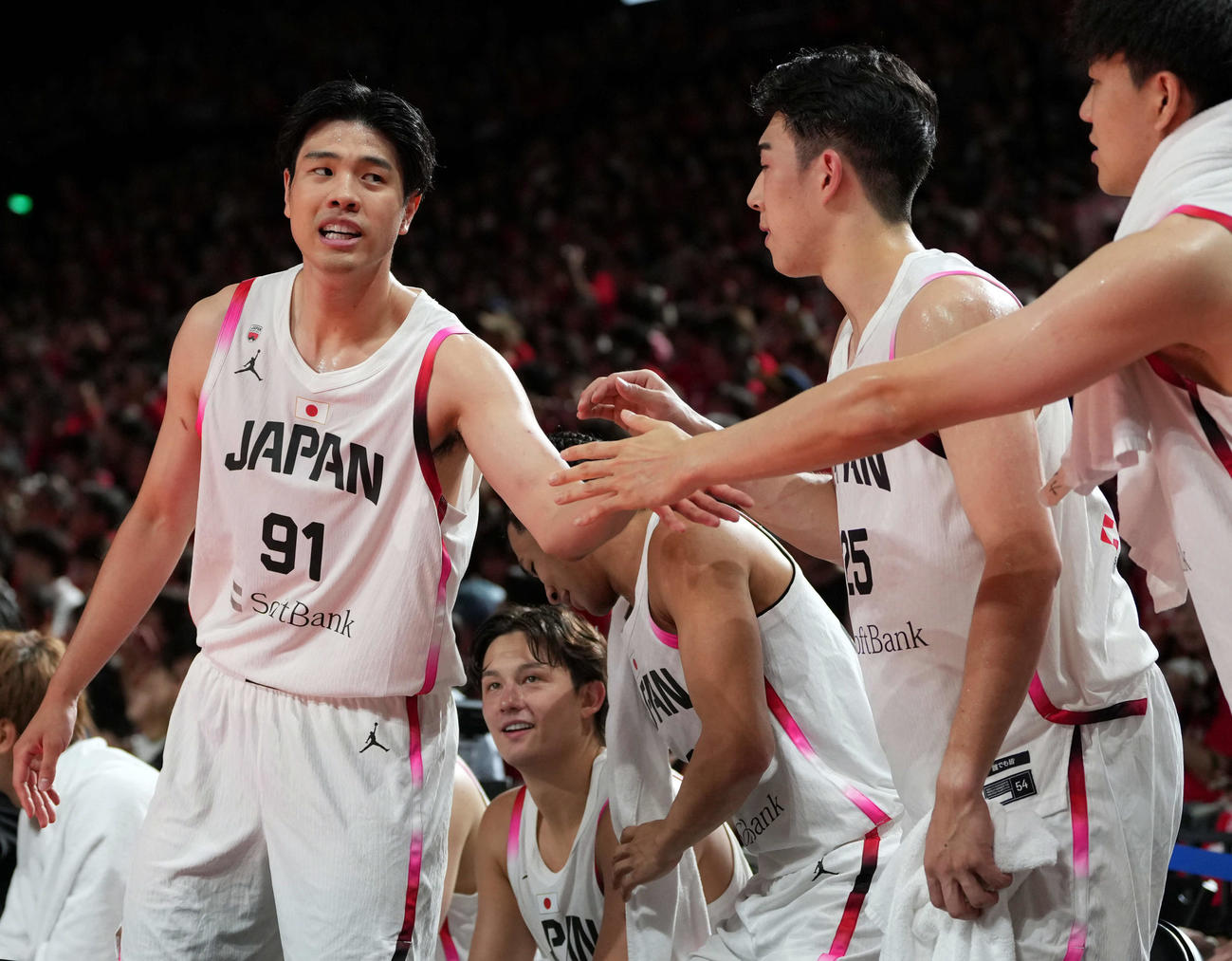 バスケットボール男子　国際強化試合　日本対デンマーク　第4Q、交代後ベンチに戻り選手とハイタッチする吉井（左）（撮影・小島史椰）