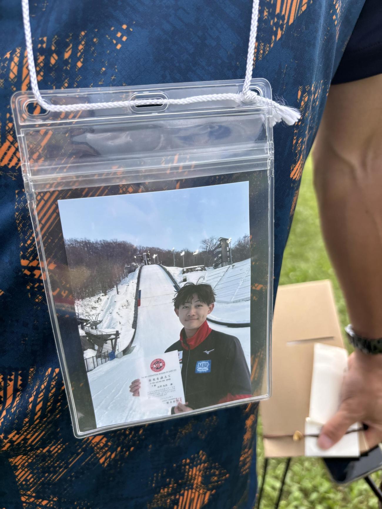 雪印メグミルク伊東監督の胸に下げられていた坂野さんの生前の写真（撮影・保坂果那）