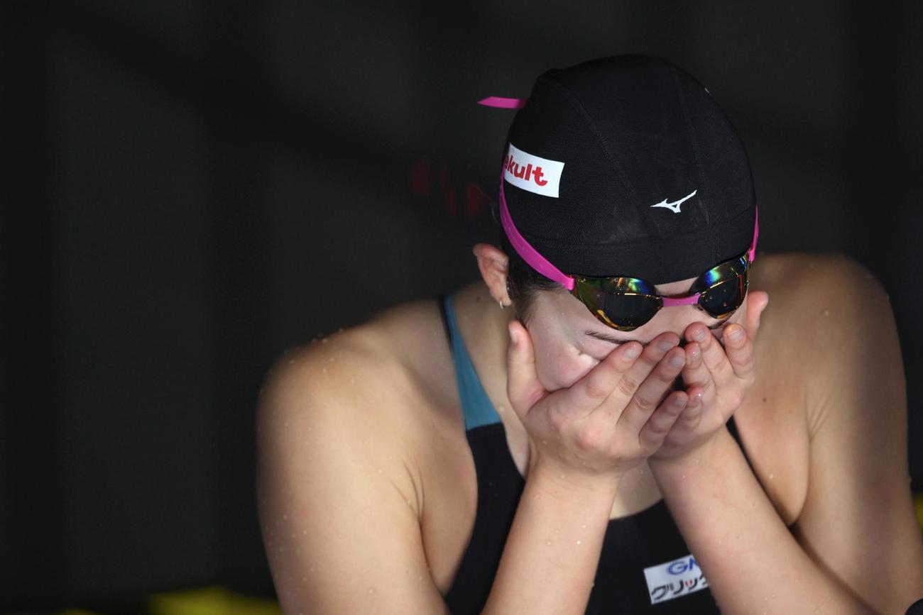 女子50メートルバタフライ準決勝で敗退し、インタビュー中に手で顔を覆う池江璃花子（共同）