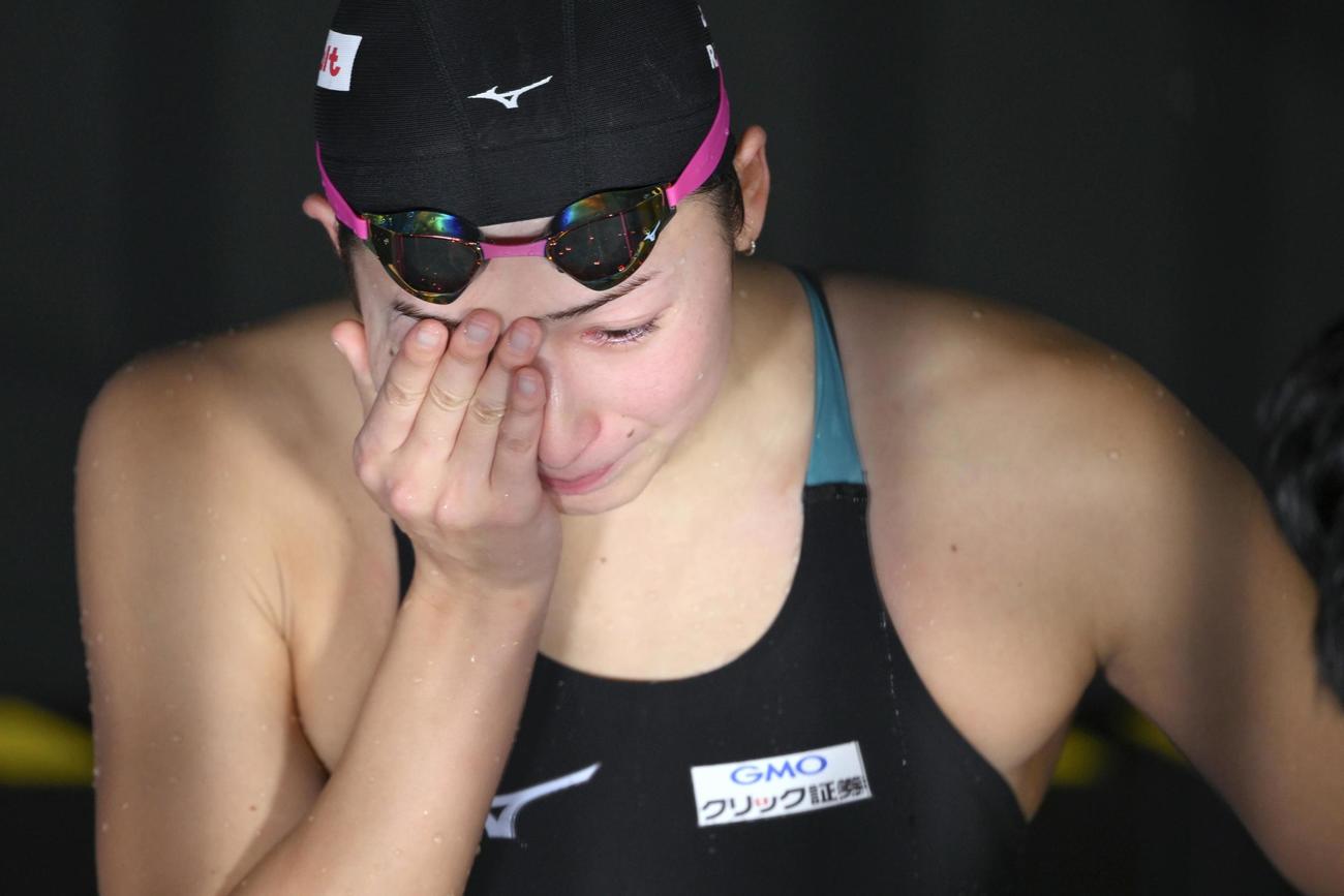 女子50メートルバタフライ準決勝で敗退し、インタビュー中に手で顔を覆う池江璃花子（共同）