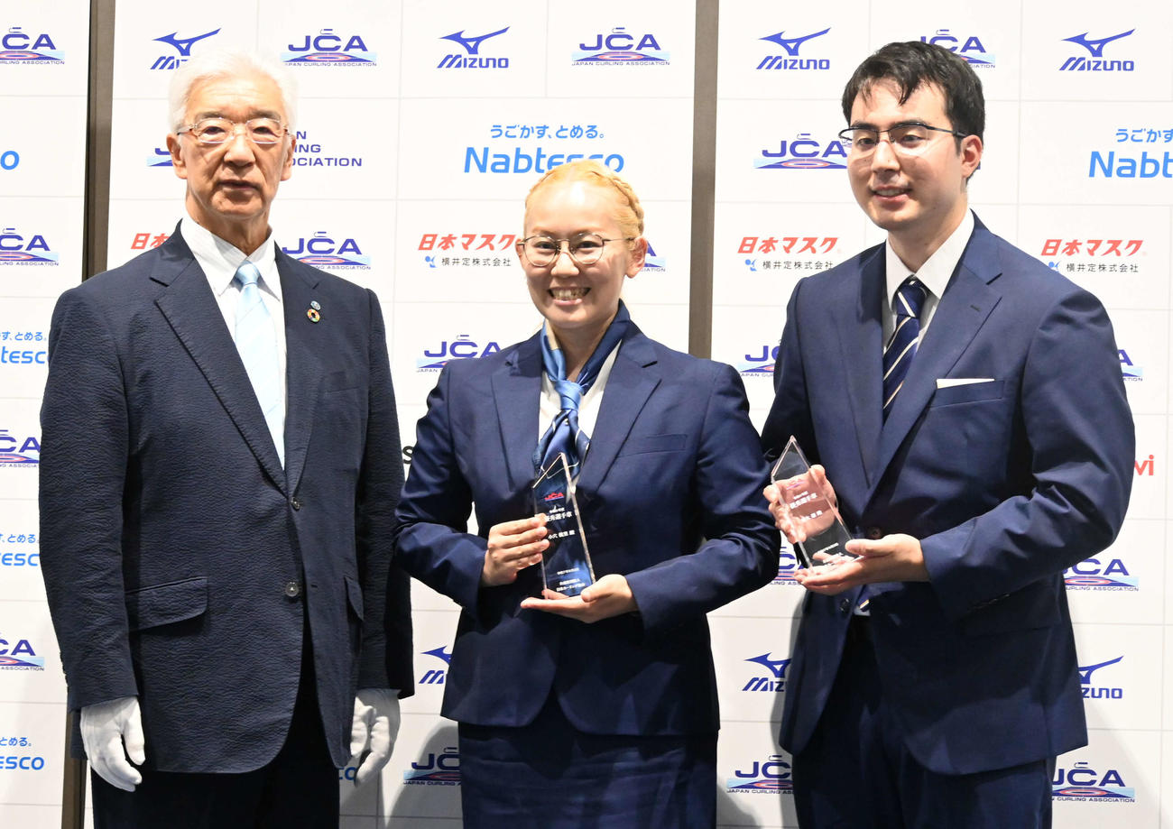 日本カーリング協会表彰式で貝森輝幸会長（左）から記念品を受け取る混合ダブルスの小穴桃里（中央）・青木豪組（撮影・飯岡大暉）