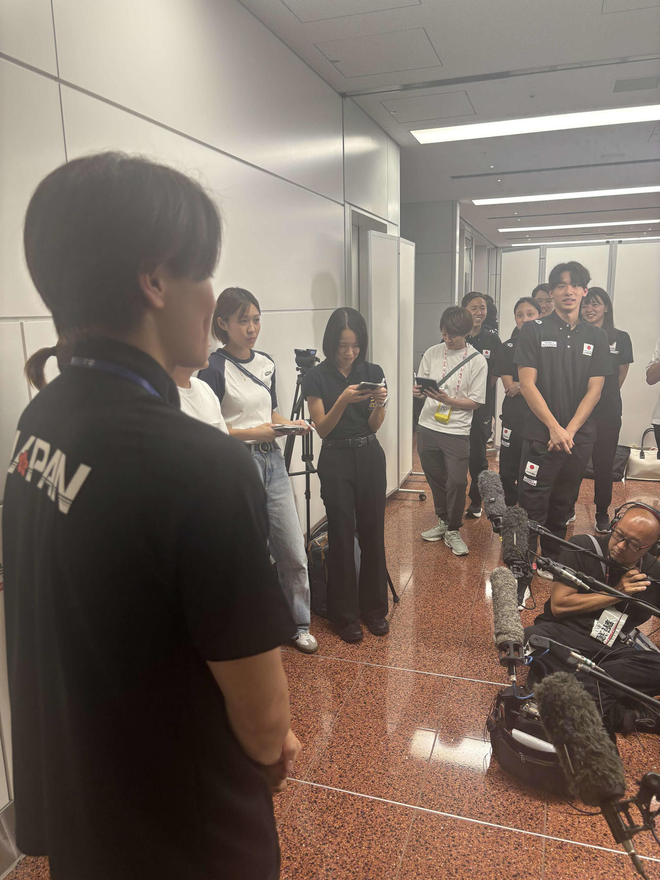 水泳の世界選手権から帰国した松下知之（左）に質問する村佐達也（右）（撮影・松本航）
