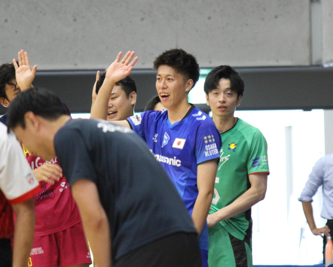 チームメートとハイタッチする富田将馬（中央）（撮影・勝部晃多）
