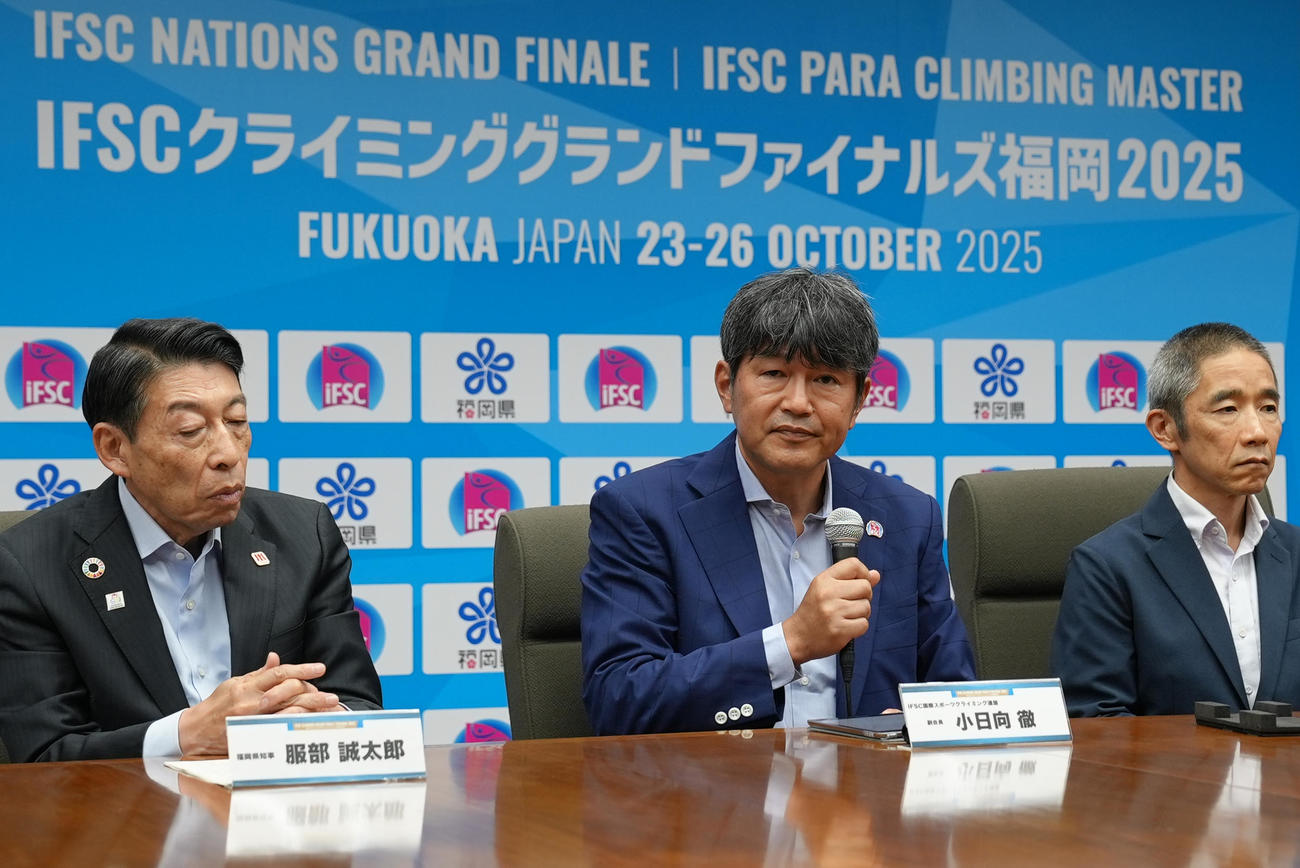 「IFSCクライミンググランドファイナルズ福岡2025」の会見に出席したIFSC小日向徹副会長（中央）や福岡県の服部誠太郎知事（左）ら