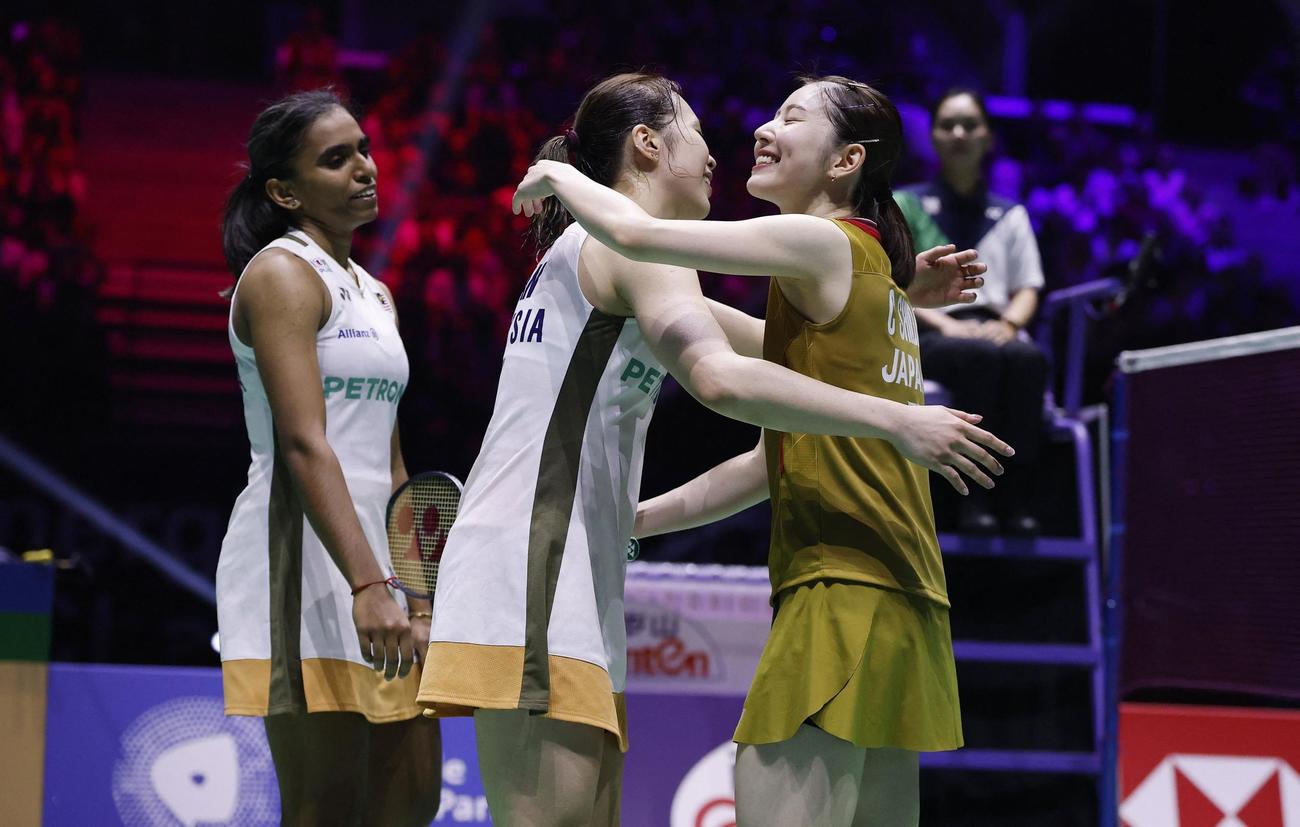 バドミントン世界選手権女子ダブルス準決勝　試合後に抱き合う志田千陽（右）とマレーシアの選手（ロイター）