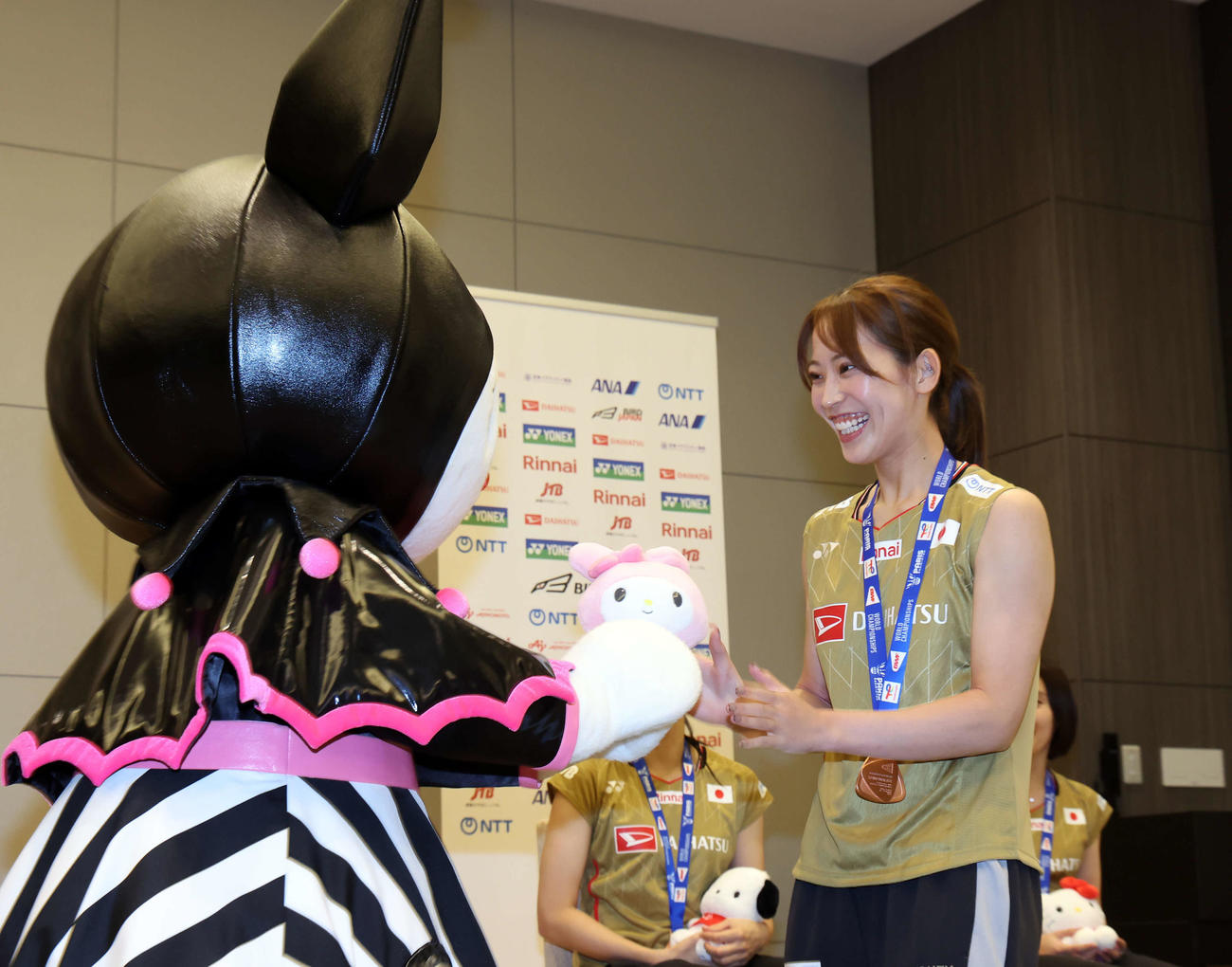 世界バドミントン選手権大会　帰国会見でサンリオのキャラクター、クロミからマイメロディの人形をプレゼントされた松山（右）（撮影・山本朝陽）