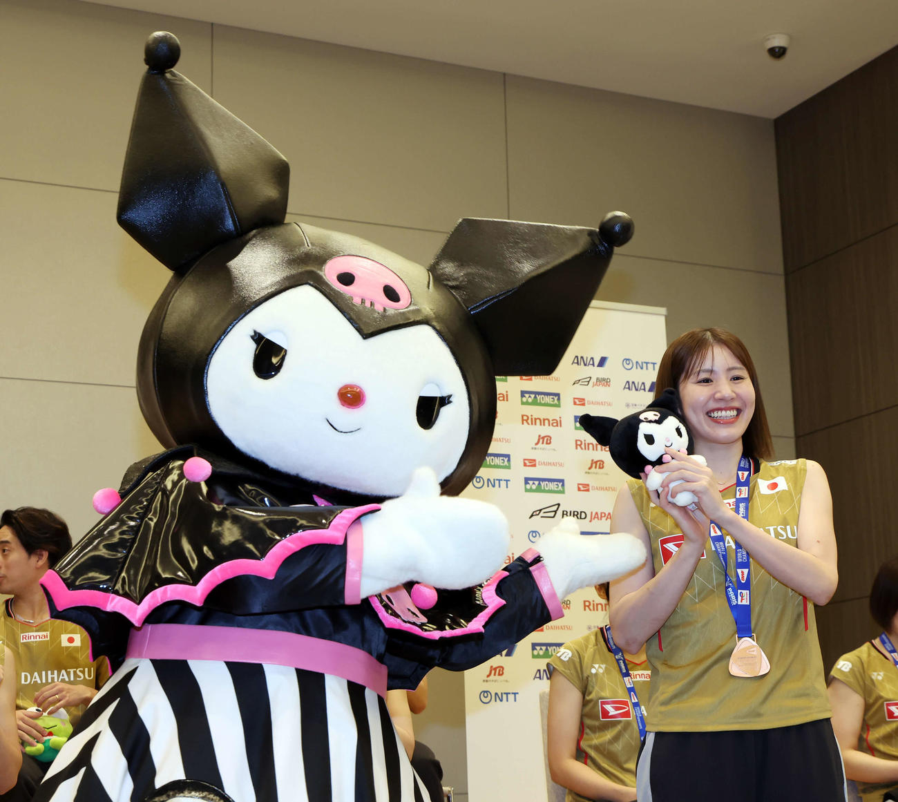 世界バドミントン選手権大会　帰国会見に登壇し、サンリオのキャラクター、クロミからクロミの人形を受け取る志田千陽（撮影・山本朝陽）