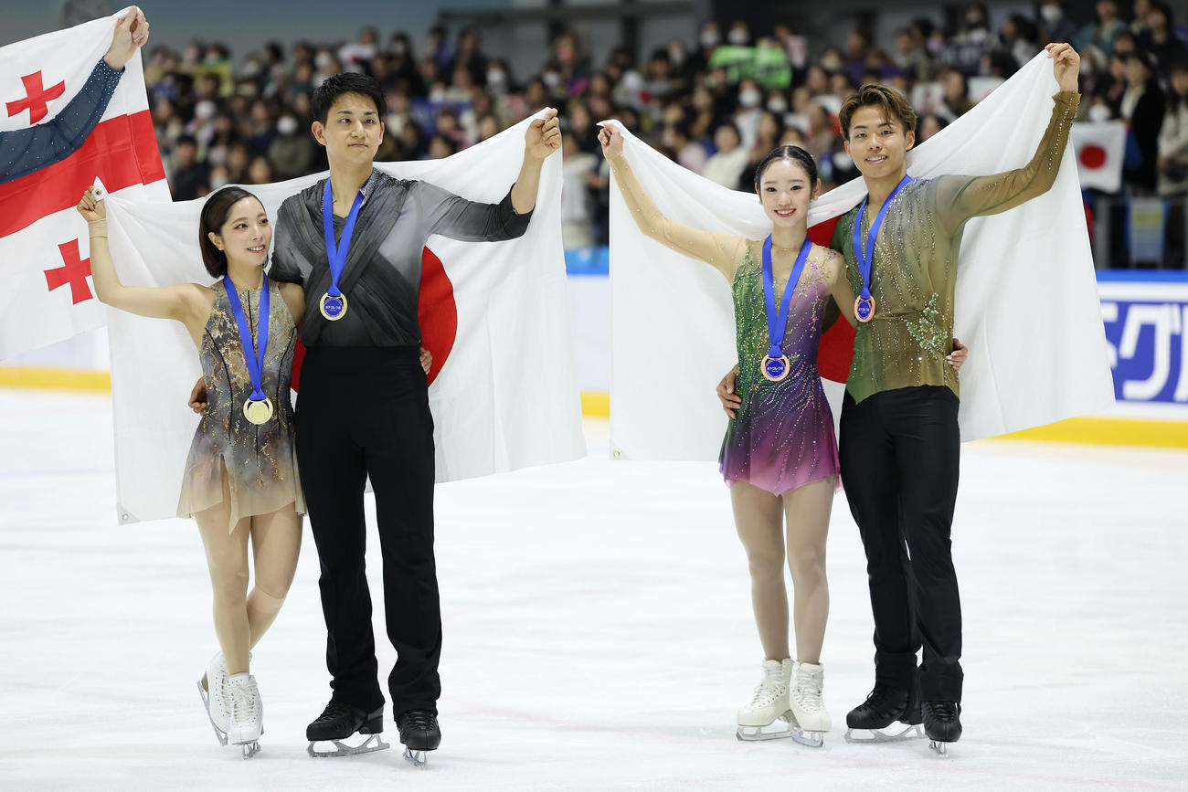 日の丸を背に笑顔を見せる、優勝した三浦、木原組（左）と3位の長岡、森口組（撮影・前田充）
