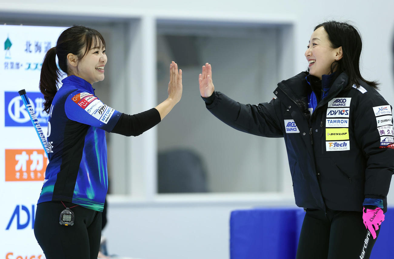 フォルティウス対ロコ・ソラーレ　第4エンド、タッチを交わすロコ・ソラーレ吉田知（左）と藤沢（撮影・前田充）