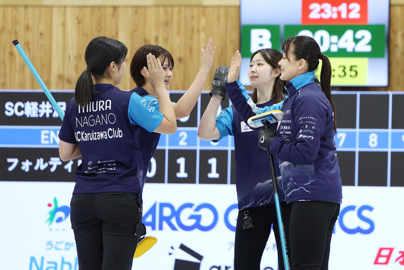 SC軽井沢クラブ対フォルティウス　第4エンド、2点を奪いタッチを交わすSC軽井沢クラブの選手たち（撮影・前田充）