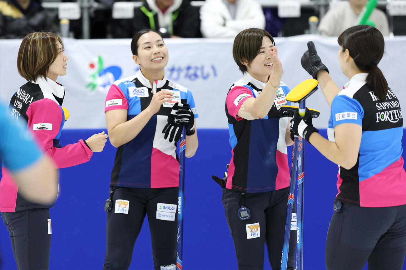 フォルティウス対SC軽井沢クラブ　第2エンド、2点を先制しタッチを交わすフォルティウスの選手たち（撮影・前田充）