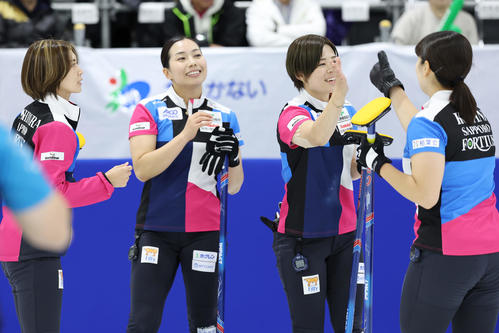 フォルティウス対SC軽井沢クラブ　第2エンド、2点を先制しタッチを交わすフォルティウスの選手たち（撮影・前田充）
