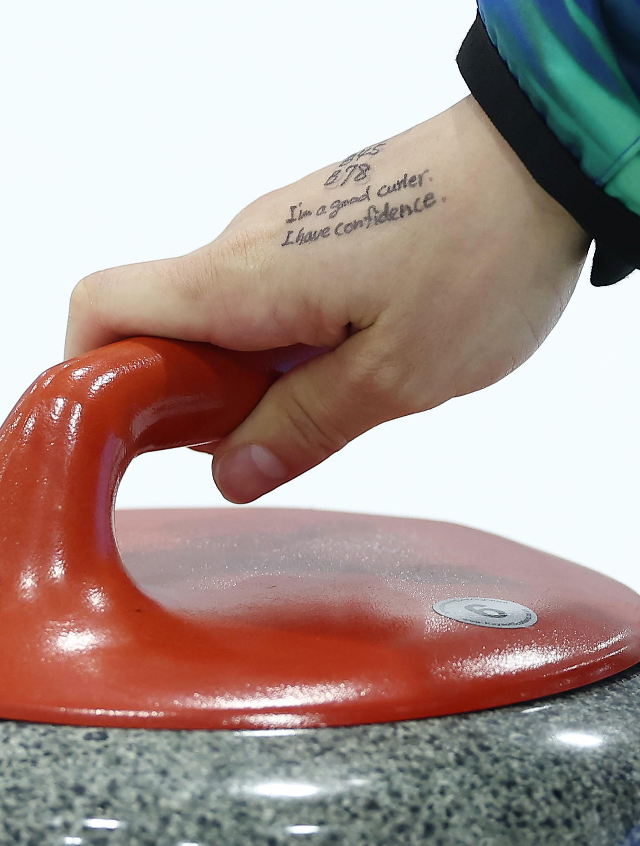 ロコ・ソラーレ対フォルティウス　第10エンド、ストーンを投じるロコ・ソラーレ藤沢の右手。「I，m a good curler．I have confidence．］と書かれていた（撮影・前田充）