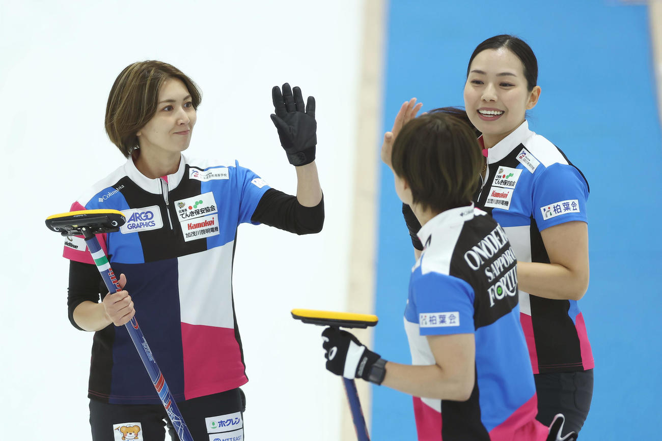 フォルティウス対SC軽井沢クラブ　第9エンド、ショットを決めタッチを交わすフォルティウス吉村（左）ら（撮影・前田充）