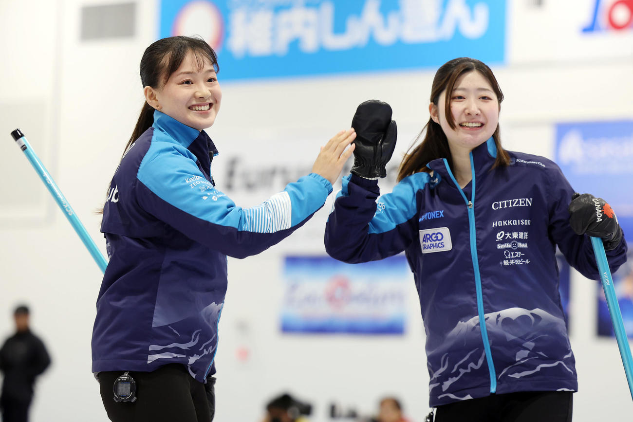 SC軽井沢クラブ対フォルティウス　第3エンド、3点を奪いタッチを交わすSC軽井沢ク上野美（左）と金井（撮影・前田充）
