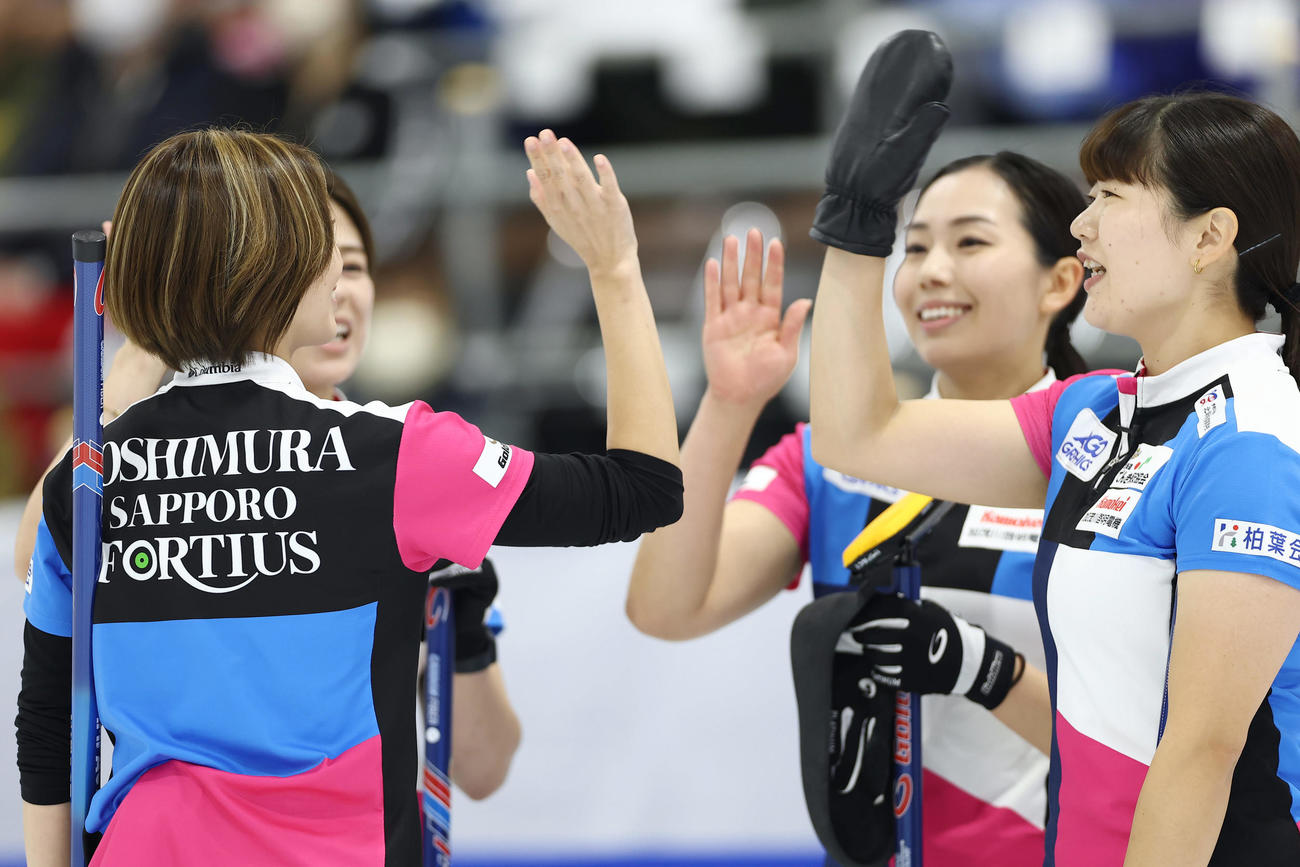 SC軽井沢クラブ対フォルティウス　第2エンド、1点を先制しタッチを交わすフォルティウスの選手たち（撮影・前田充）
