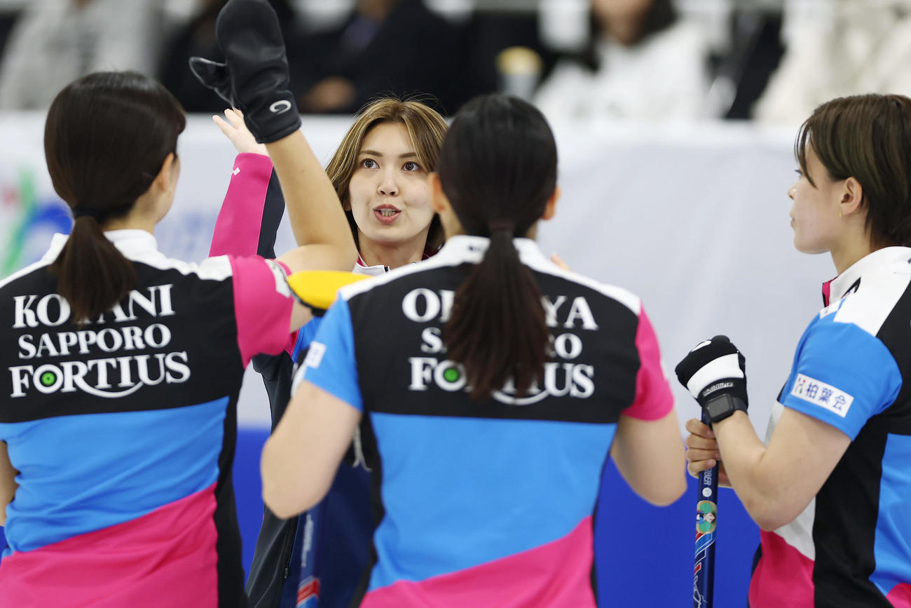 SC軽井沢クラブ対フォルティウス　第2エンド、1点を先制しタッチを交わすフォルティウスの選手たち（撮影・前田充）