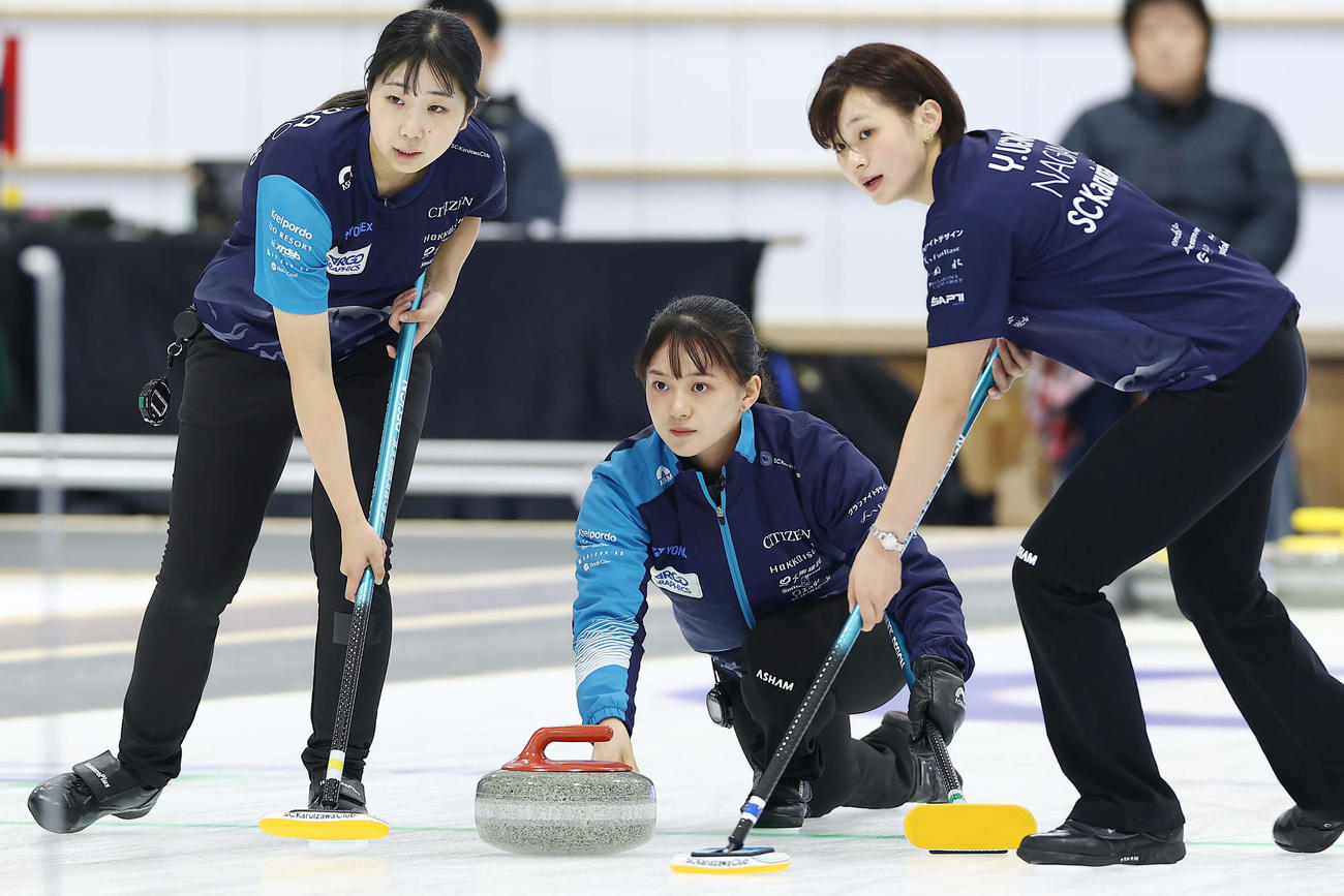 SC軽井沢クラブ対フォルティウス　第1エンド、ストーンを投じるSC軽井沢ク上野美。左は三浦、右は上野結（撮影・前田充）