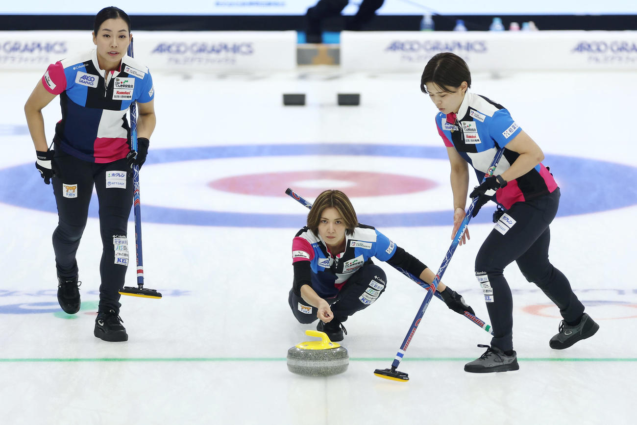 SC軽井沢クラブ対フォルティウス　第7エンド、ストーンを投じるフォルティウス吉村。左は近江谷、右は小野寺（撮影・前田充）